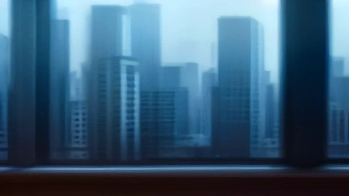 shallow depth of field close-up of a panoramic city skyline seen through an office window, subtle blue tones, used as the opening image